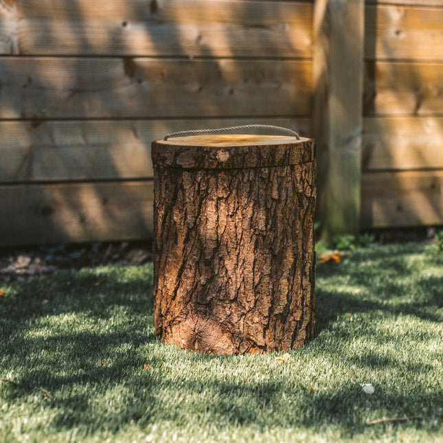 De urn is gemaakt van elzen hout een heeft de vorm van een cilinder. De urn kan boven opengemaakt worden door een touw die vast zit aan de deksel. De urn staat gestationeerd in de tuin op het kunstgras.